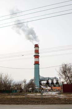 A patriotic chimney emits smoke against a backdrop of blue sky, white clouds, and green trees. The red, white, and blue colors symbolize America