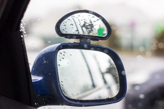 A vehicles sideview mirror with a green sticker attached, enhancing safety and visibility. The automotive exterior design feature adds style to the car