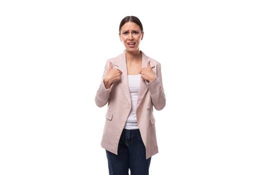 portrait of a young slender brunette business woman with ponytail dressed in a jacket and jeans.