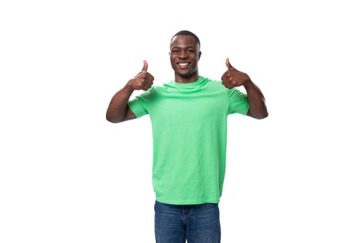 young american man dressed in a green corporate t-shirt on a white background with copy space.