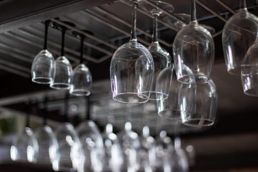 A collection of elegant stemware hanging from a chandelier rack, creating a stunning display of drinkware in a sophisticated event space