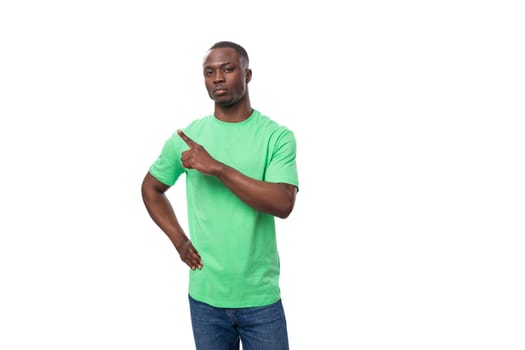 young handsome african man in light green t-shirt and jeans tells interesting news.