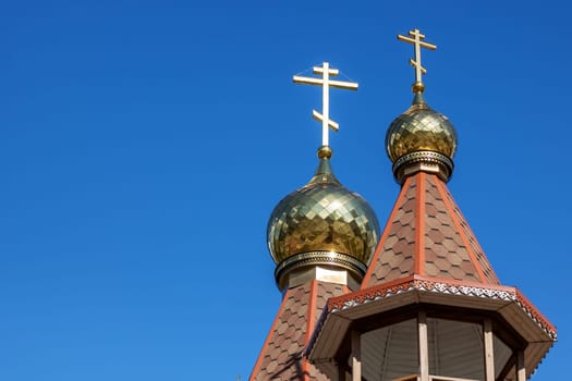 The church building features two gold crosses on the steeple, reaching up into the sky as a prominent finial atop the roof