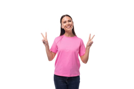young beautiful model woman with straight black hair dressed in a pink t-shirt feels joy.