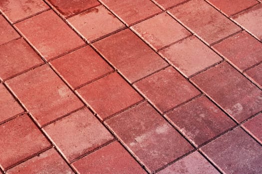 An upclose shot of a diagonal patterned red brick floor, resembling brown brickwork. The rectangular shapes create a unique flooring design