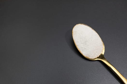 Design Celtic Gray Sea Salt In Golden Spoon on Dark Table, Copy Space. Horizontal Plane. Natural And Unrefined Salt Harvested From Brittany, France. Natural Minerals And Trace Elements, Superfood.