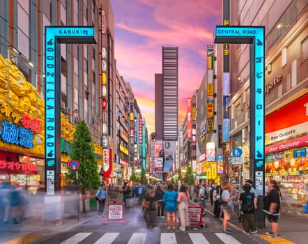 tokyo, japan - apr 28 2024: Sunset view of the illuminated gate of the Central Road of Kabukicho called Godzilla Road leading to the Toho Cinema skyscraper overlooked by its famous Godzilla head.