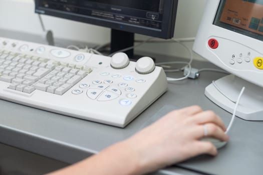 Doctor using laptop and electronic medical record (EMR) system. Digital database of patient's health care and personal information on computer screen. Hand on mouse and typing with keyboard.