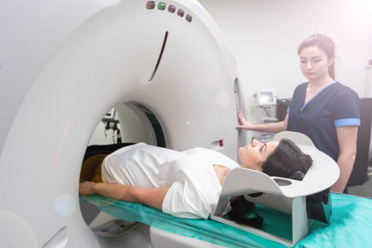 A woman lies on the tomograph table. woman is undergoing computed axial tomography examination in a modern hospital.