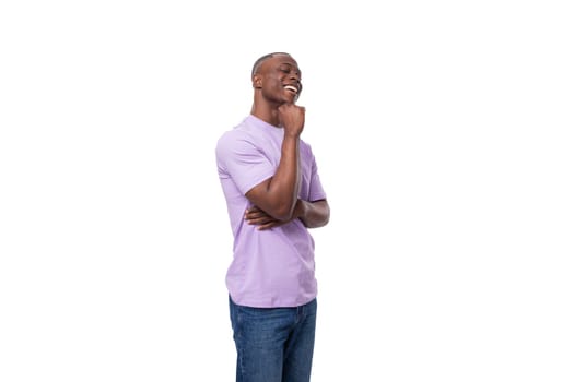 young smart slender American student guy dressed in a light lilac T-shirt and jeans.