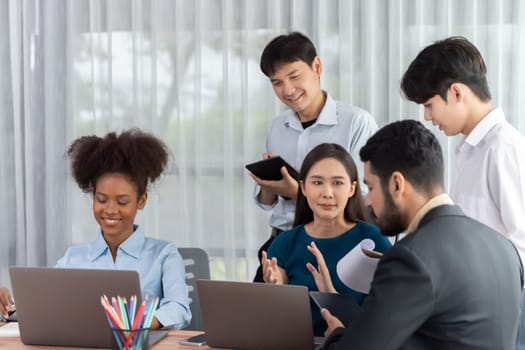 Happy diverse business people work together, discussing in corporate office. Professional and diversity teamwork discuss business plan on desk with laptop. Modern multicultural office worker. Concord