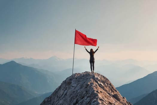 A triumphant individual standing atop a mountain holding a red flag demonstrates victory. Perfect for motivational, success or extreme sport themes.