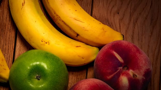 Apple, peach and bananas on a wooden board. Composition of healty fruits.