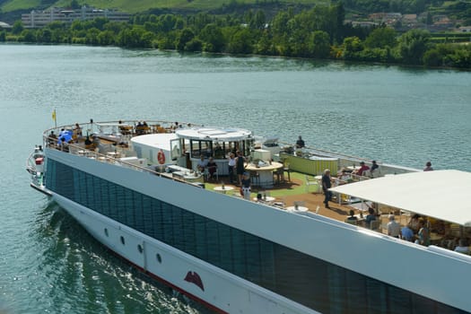 Vaugry Gard, France - May 30, 2023: A large boat packed with numerous individuals, sailing on the water.