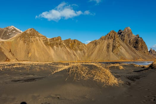 Vestrahorn rocky mountains in iceland, stokksnes beach forming beautiful scandinavian landscape. Gorgeous scenery with famous black sand beach, icelandic nature on ocean coastline.
