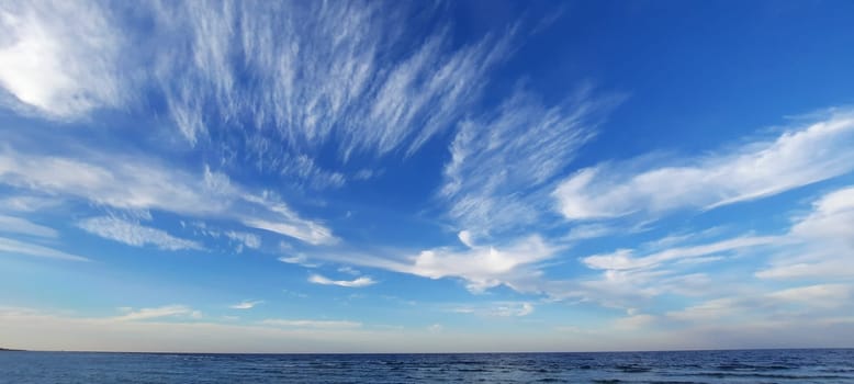 Red sea, Egypt. April 2024. Blue sea and sky background, blue shades horizon. White clouds on clear sky over sea water surface. Tranquil ocean with ripples. High quality photo