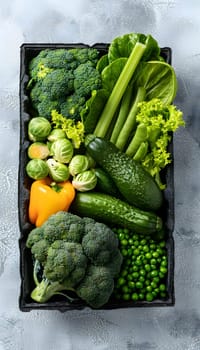A black box filled with an assortment of green vegetables, including leafy greens, green bell peppers, and squash, representing a variety of natural foods in the staple food group