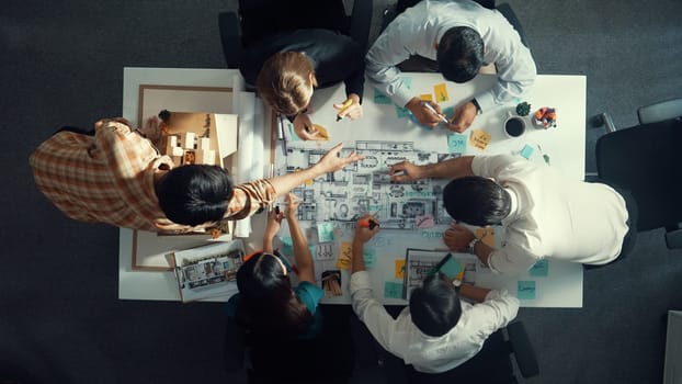 Top aerial view of project manager or civil engineer writing at blueprint and planning building design. Aerial view of architect working together at meeting table with document placed. Alimentation.