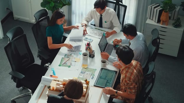 Group of diverse team planning strategy while sitting at table with project plan. Top aerial view of smart business people working together to brainstorm and design house construction. Alimentation.