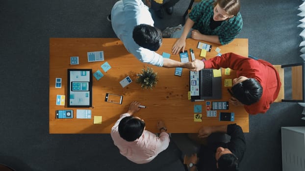 Top view of developer and designer shake hand together at meeting. Software developer handshake and working together with programmer to develop Ux Ui desifn for mobile phone interface. Convocation.