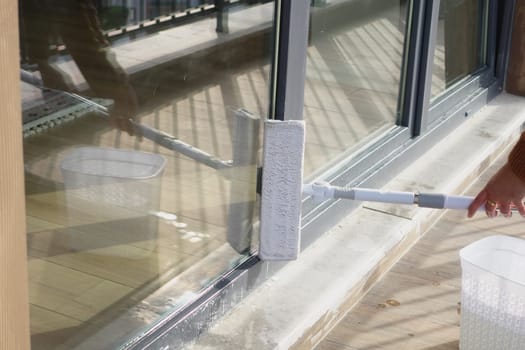 Rubber squeegee cleans a soaped window