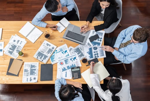 Panorama top view diverse group of business analyst team analyzing financial data report paper on meeting table. Chart and graph dashboard by business intelligence analysis. Meticulous