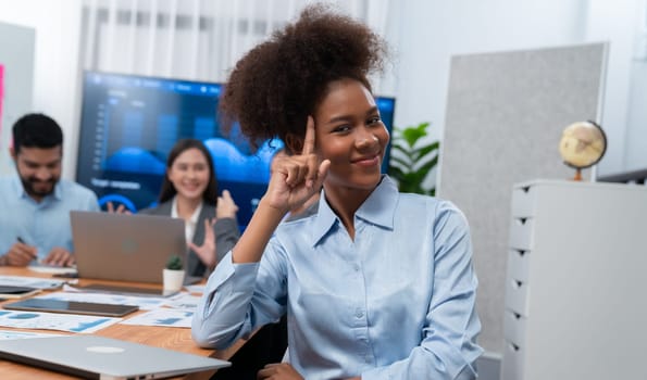 Portrait of happy young african businesswoman with group of office worker on meeting with screen display business dashboard in background. Confident office lady at team meeting. Concord