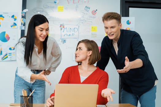 Professional business team working together by using laptop in start up project at meeting in front of glass board with mind map while colleague brainstorm and discuss about strategy. Immaculate.