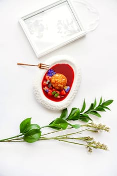 Dessert fried ice cream in strawberry sauce with berries. Top view with copy space on white table