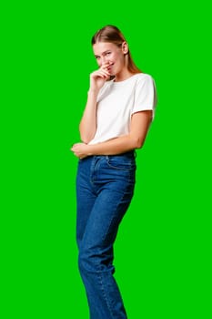 Smiling Young Woman in Casual Outfit Posing Against Green Background in studio