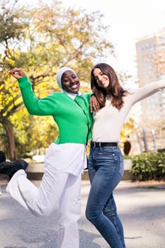 multiracial couple of two young women having fun looking at camera, concept of friendship and happiness, copy space for text