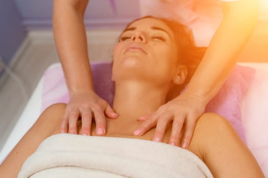 Masseur woman massages her shoulders. Woman getting a massage at the spa.