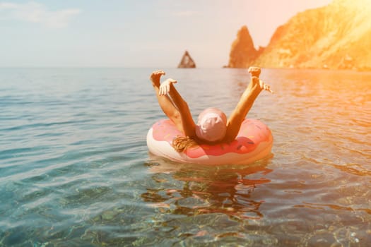 Summer vacation woman in hat floats on an inflatable donut mattress. Happy woman relaxing and enjoying family summer travel holidays travel on the sea