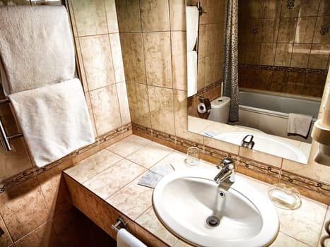 Modern bathroom interior with sink and mirror. Elegant marble bathroom featuring a sink and lit wall mirror