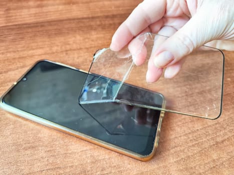Removing Protective Film From Cracked Screen. Peeling off a cracked screen protector from a phone
