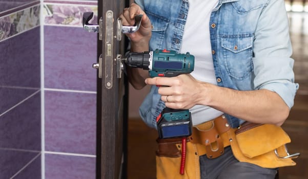 Handyman Fitting A New Door Using A Screwdriver At Home.