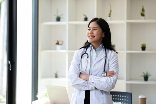 Portrait of confident young female doctor standing in clinic.