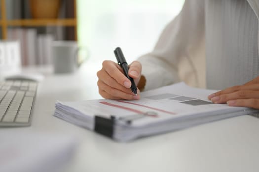 Closeup businesswoman writing strategy ideas on paper at office desk.