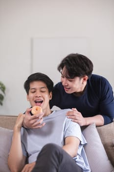 A male-male couple spends their free time happily doing holiday activities together, embracing each other and taking selfies together in the living room..