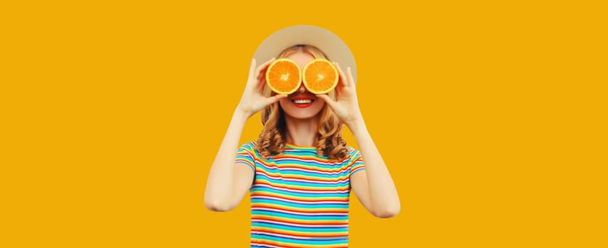 Summer vacation portrait of happy smiling young woman with fresh juicy fruits, slice of orange on yellow studio background