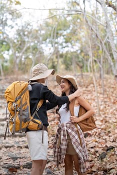Happy LGBT lesbian couple travel enjoy hiking with backpack in forest trail.