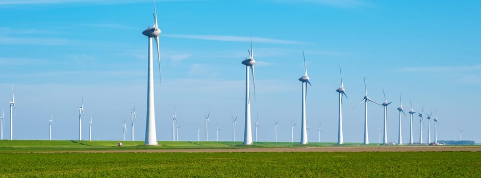 Row of sleek wind turbines spinning gracefully in a vast green field, harnessing the power of the wind to generate clean energy. banner of windmill turbines