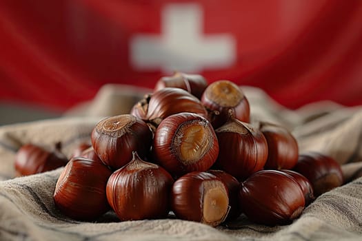 A bunch of chestnuts on burlap against the background of the Swiss flag.