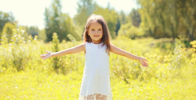 Portrait of happy little girl child walking in sunny summer park