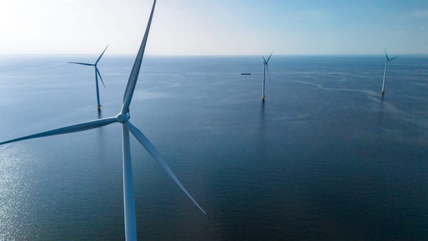 A group of majestic wind turbines stand tall in the ocean, their blades gracefully turning in the wind to generate clean, renewable energy.