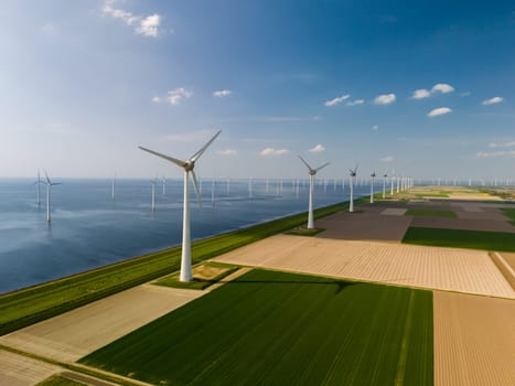 A mesmerizing aerial view captures a wind farm near the ocean in the Netherlands Flevoland, where majestic windmill turbines harness the power of the sea breeze.