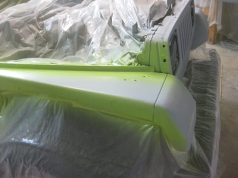 Auto Body Work, Beginning Lime Green Paint Coat on Fender, 1990s Vehicle . High quality photo