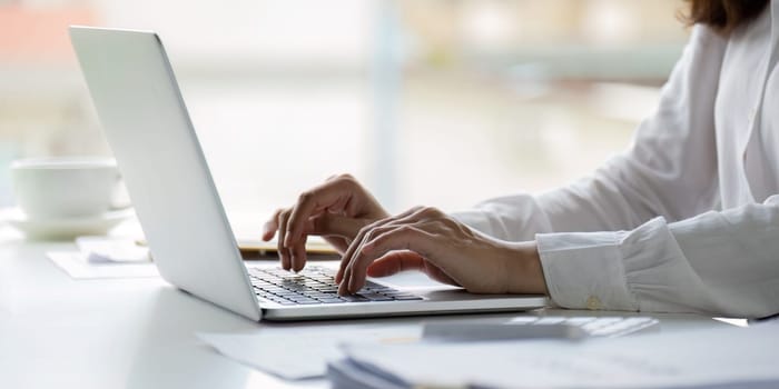 Professional businesswoman working at her office on laptop, work process concept.