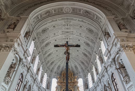 Munich, Germany - Dec 21, 2023 - Jesus hanging on the cross, Crucifix in the interior of St. Michael's Church (Michaelskirche Jesuit church) in Munich pedestrian zone. It is the largest Renaissance church north of the Alps. Space for text, Selective focus.