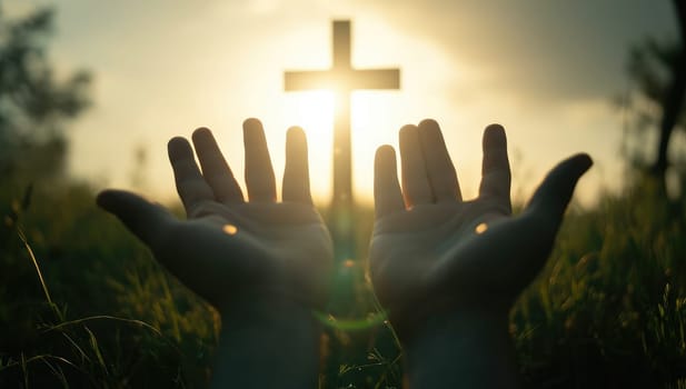 Silhouette of hands holding a christian cross in the field